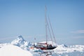 Yacht navigating its way through close packed icebergs in the Ilullisat icefjord, Greenland