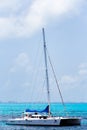 Tall luxury sailboat yacht floating on clear blue tropical water