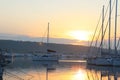 The yacht returns from the voyage to the marina during the morning dawn sailing past the moored sailing yachts. Marine life style. Royalty Free Stock Photo