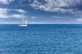 Yacht sailboat. Yacht sailboat sailing alone on calm blue sea waters on a beautiful sunny day with blue sky and white clouds