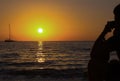 Yacht sailing bright sunset golden sun silhouette of a man on the shore looking into the distance on a ship in the sea Royalty Free Stock Photo