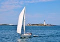 Yacht Sailing in front of Boston Harbor Lighthouse Royalty Free Stock Photo