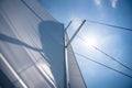 Yacht sailing in an open sea. Close-up view of sails of a sailing yacht in the wind and clear sky with sun Royalty Free Stock Photo