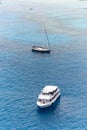 Yacht sailing in open sea next to a little boat