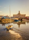 Yacht sailing to its mooring in Ramsgate Royal harbour, the historic listed building of the clock house and tower can be seen. Royalty Free Stock Photo