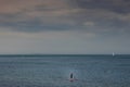 Yacht sailing towards sunset in blue background, Royalty Free Stock Photo