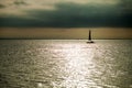 The yacht sailing on the waves of the sea bay in the rays of the Royalty Free Stock Photo