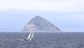 A Yacht Sails in Front of the Island of Ailsa Craig Royalty Free Stock Photo
