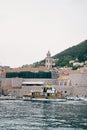 Yacht sails on the sea past the old high fortress wall of Dubrovnik. Croatia