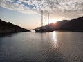 Yacht silhouette at sunset. A yacht in the sea against the backdrop of mountains, sky and clouds in sunset colors Royalty Free Stock Photo