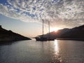 Yacht silhouette at sunset. A yacht in the sea against the backdrop of mountains, sky and clouds in sunset colors Royalty Free Stock Photo