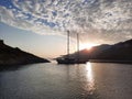 Yacht silhouette at sunset. A yacht in the sea against the backdrop of mountains, sky and clouds in sunset colors Royalty Free Stock Photo