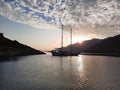 Yacht silhouette at sunset. A yacht in the sea against the backdrop of mountains, sky and clouds in sunset colors Royalty Free Stock Photo