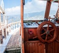 Yacht steering wheel and control panel. Ready to sea travel. Wooden deck interior of sailing boat. Ship on pier. Good Royalty Free Stock Photo