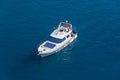 Yacht with sun loungers at the stern floating on the water surface in summer, aerial top view Royalty Free Stock Photo