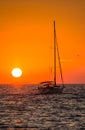 Yacht sunset silhouette in the sea with setting sun and orange sky in Croatia vertical