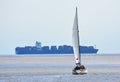 Yacht under Sail with large container ship in the background. Royalty Free Stock Photo