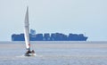 Yacht under Sail with large container ship in the background. Royalty Free Stock Photo
