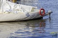 Yacht with a white sail on the blue water. At the stern red life Royalty Free Stock Photo