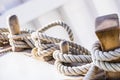 Maritime nautical ropes tied on wood cleats of old sailboat Royalty Free Stock Photo