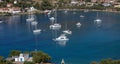 Yachts, boats are anchored at Otzias bay. Village, sandy beach background. Kea, Tzia, Greece Royalty Free Stock Photo