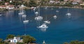 Yachts, boats are anchored at Otzias bay. Village, sandy beach background. Kea, Tzia, Greece