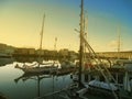 Yachts and boats stand at the pier in the port at sunset