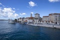 Yachts dock at the pier and tourists visit the promenade of the ancient Venetian city near the Adriatic Sea, Trogir, Croatia Royalty Free Stock Photo