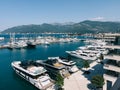 Yachts are moored on the pier near the hotel against the backdrop of the mountains