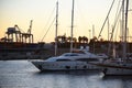 Yachts and motor boats in La Marina de Valencia. Luxury yacht and fishing motorboat in yacht club on sunset. Skiff and Sailboat in Royalty Free Stock Photo