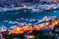 Yachts and ships in the gulf in evening. Illumination at night. Travelling to sea