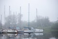 Yachts are small vessels moored to a pier in a thick fog. Sights, old harbor Royalty Free Stock Photo