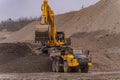 A Komatsu PC1250 excavator loads ore into a Komatsu HM400 dump truck.