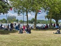 Sailboats fans enjoy big outdoor entertainment event. Open air festival Picnic. Big group of people on grass waiting for armada