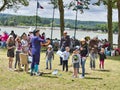 Sailboats fans enjoy big outdoor entertainment event. Open air festival Picnic. Big group of people on grass waiting for armada