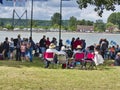 Sailboats fans enjoy big outdoor entertainment event. Open air festival Picnic. Big group of people on grass waiting for armada