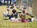 Sailboats fans enjoy big outdoor entertainment event. Open air festival Picnic. Big group of people on grass waiting for armada