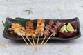 Yakitori Japanese-Style Grilled Chicken Skewers with chicken and internal organ served with sliced lime on black stone. Royalty Free Stock Photo