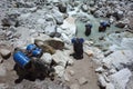 Yaks caravan loaded with big blue barrels is crossing river. Everest trek, Nepal