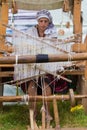 Woman artist works at ancient loom, weaving carpet
