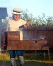 Yakut Asian girl in glasses and hat waving a fire fan in the grill with cooking meat. Royalty Free Stock Photo