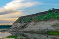 Yakut Asian girl-the tourist-fisherman with a backpack is fishing on the river Kempendyay the hill of the cliff at sunset in the w Royalty Free Stock Photo