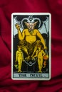 THE FOOL major tarot card of Rider Waite deck on red fabric background