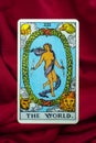 THE FOOL major tarot card of Rider Waite deck on red fabric background
