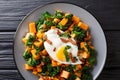 Yam with kale, bacon and fried egg close-up on a plate. horizontal top view Royalty Free Stock Photo