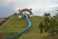 Long blue slide on green hill