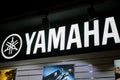 Yamaha music brand logo on black wall with musicians photo