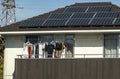 A house with solar panels on the roof and drying cloths on a balcony.