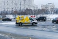 Yandex Market van is driving on city road in winter. White cargo van branded with the Yandex Market logo. Delivery of orders from