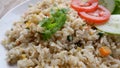 Yang Chow fried rice with slice tomato and cucumber on a white plate